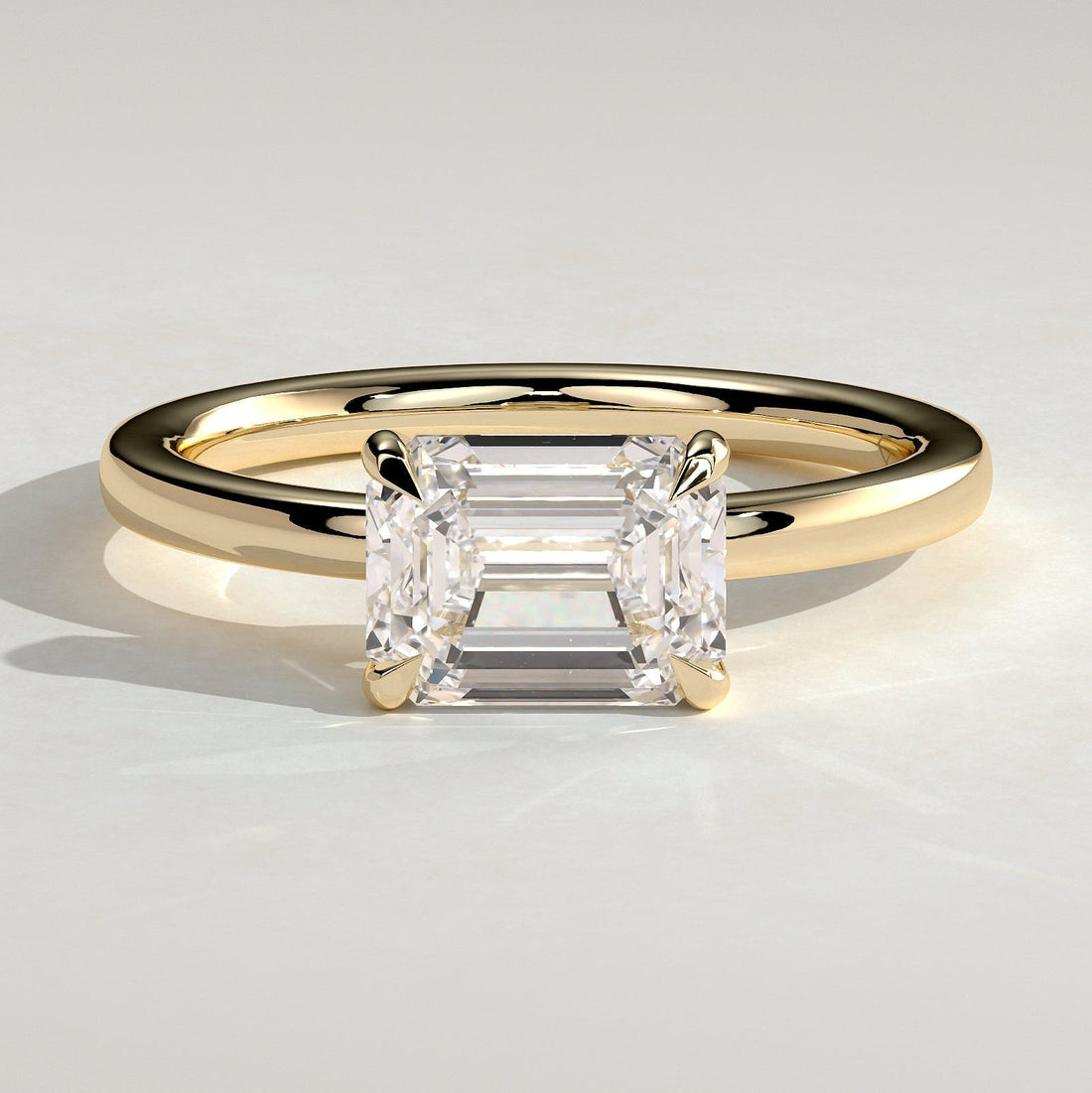East west emerald cut lab grown diamond bar set ring in yellow gold