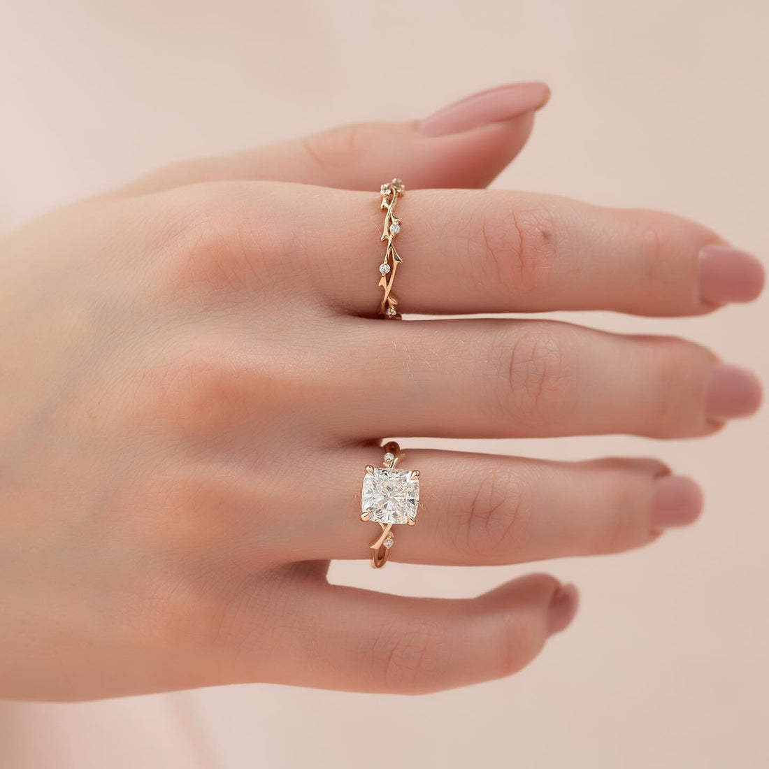 Cushion cut lab grown diamond ring with vine and leaf band in rose gold worn on the hand