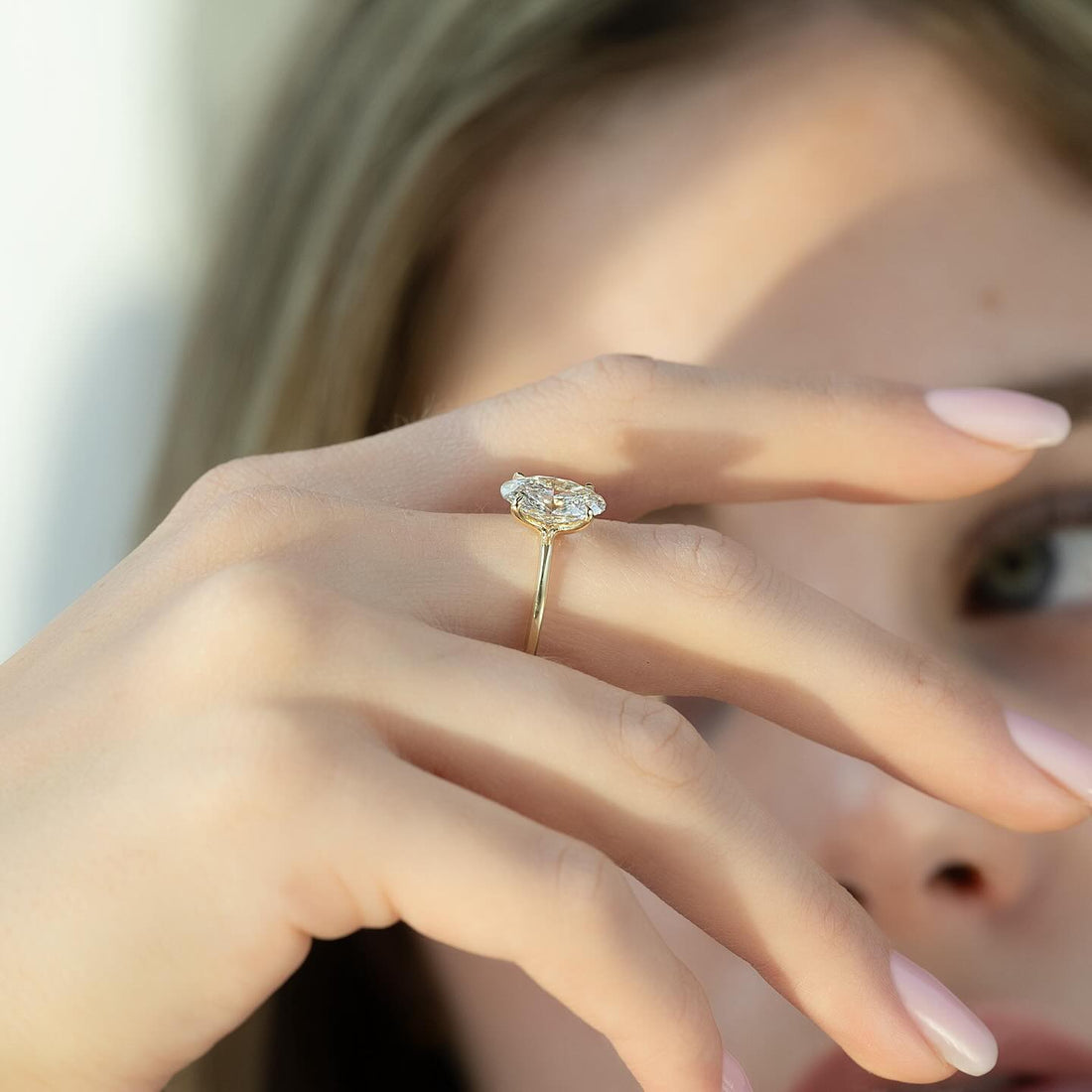 East west marquise cut lab grown diamond solitaire ring in yellow gold worn on the hand
