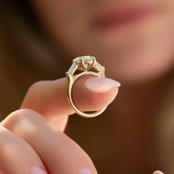 Tapered baguette diamonds narrowing away from the oval centre stone