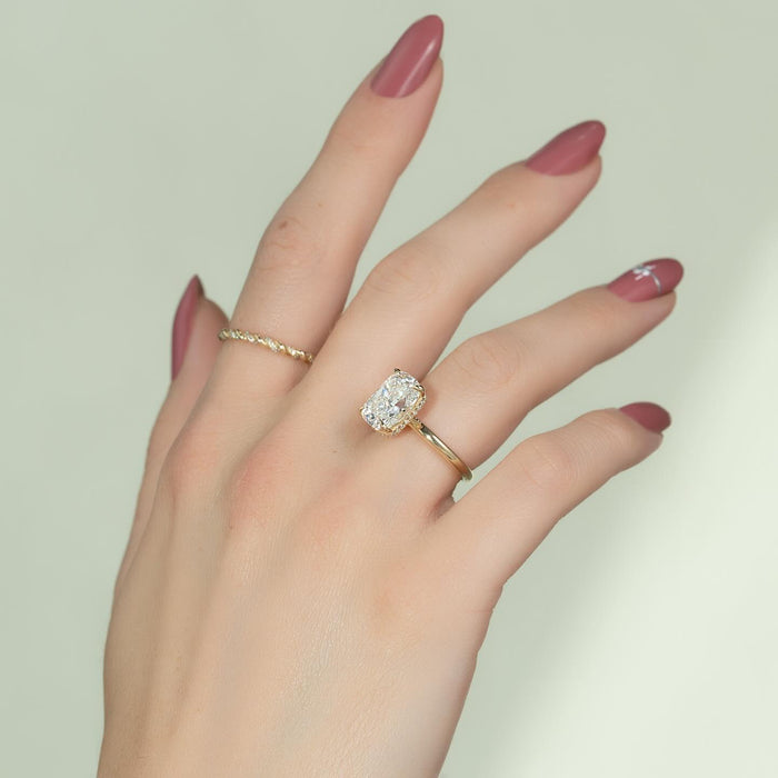 Elongated cushion cut lab grown diamond hidden halo ring in yellow gold worn on the hand