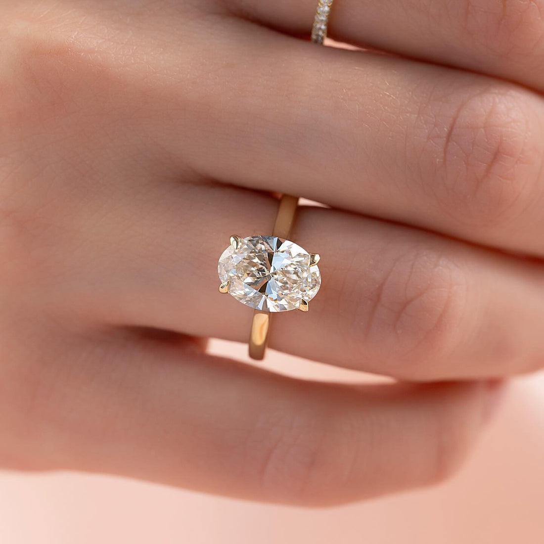 East west oval lab grown diamond ring with hidden halo in yellow gold