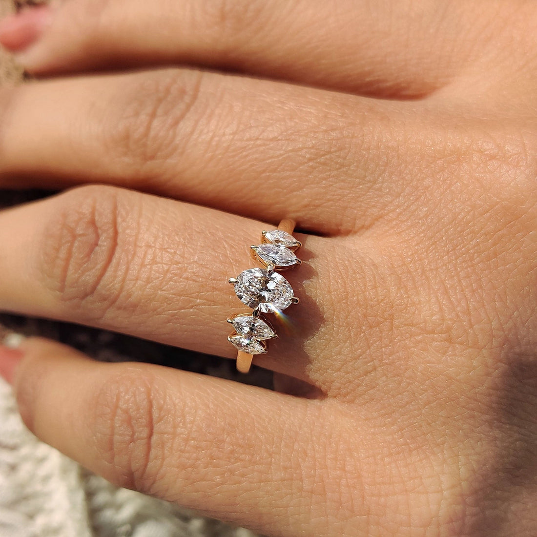 Oval cut lab grown diamond cluster ring with marquise accents seen from the front