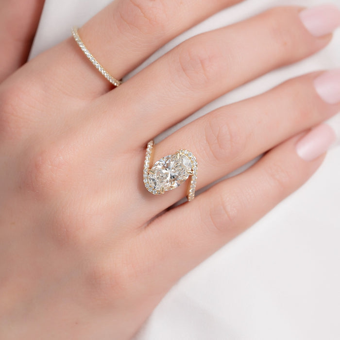 Bypass engagement ring showing the two arms passing the oval diamond