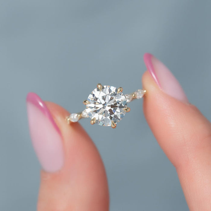 Round cut lab grown diamond eight claw ring with marquise accent band in yellow gold