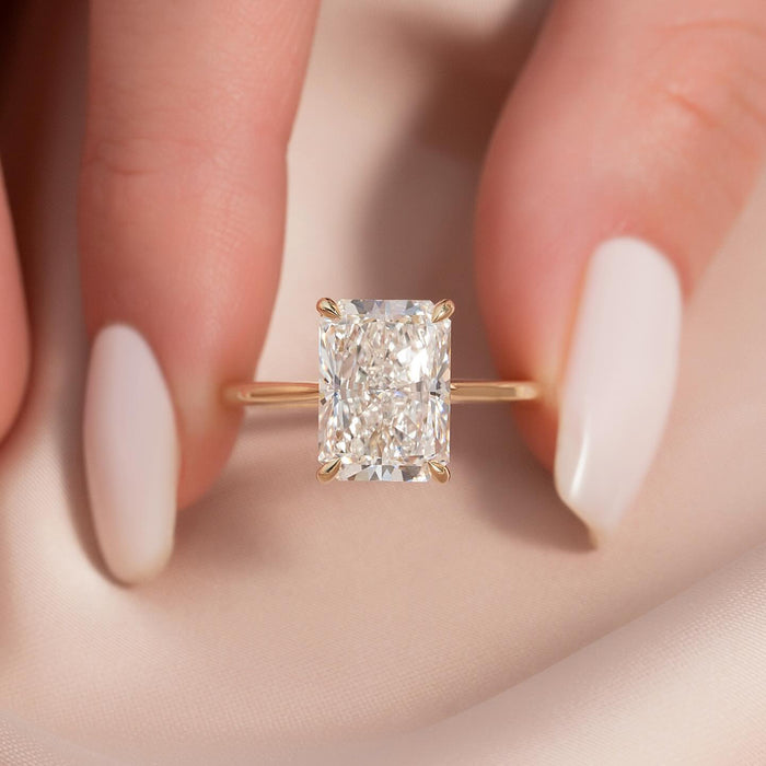 Radiant cut lab grown diamond solitaire on a thin yellow gold band, front view