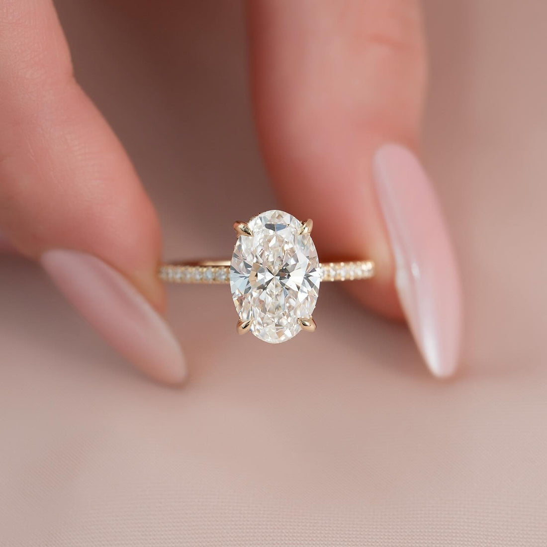 Oval cut lab grown diamond ring with hidden halo on an ultra thin pave band in yellow gold