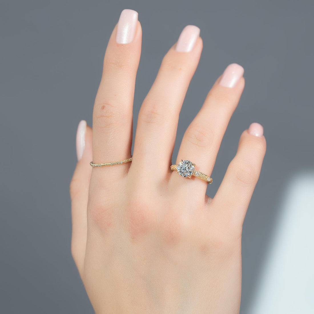 Round cut lab grown diamond hidden halo ring with milgrain vintage band worn on the hand