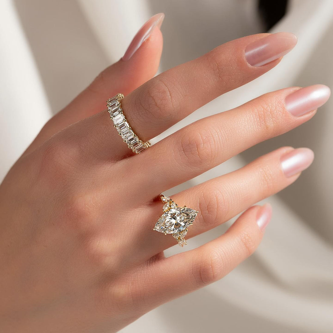 East west marquise lab grown diamond ring with marquise accent clusters in yellow gold worn on the hand