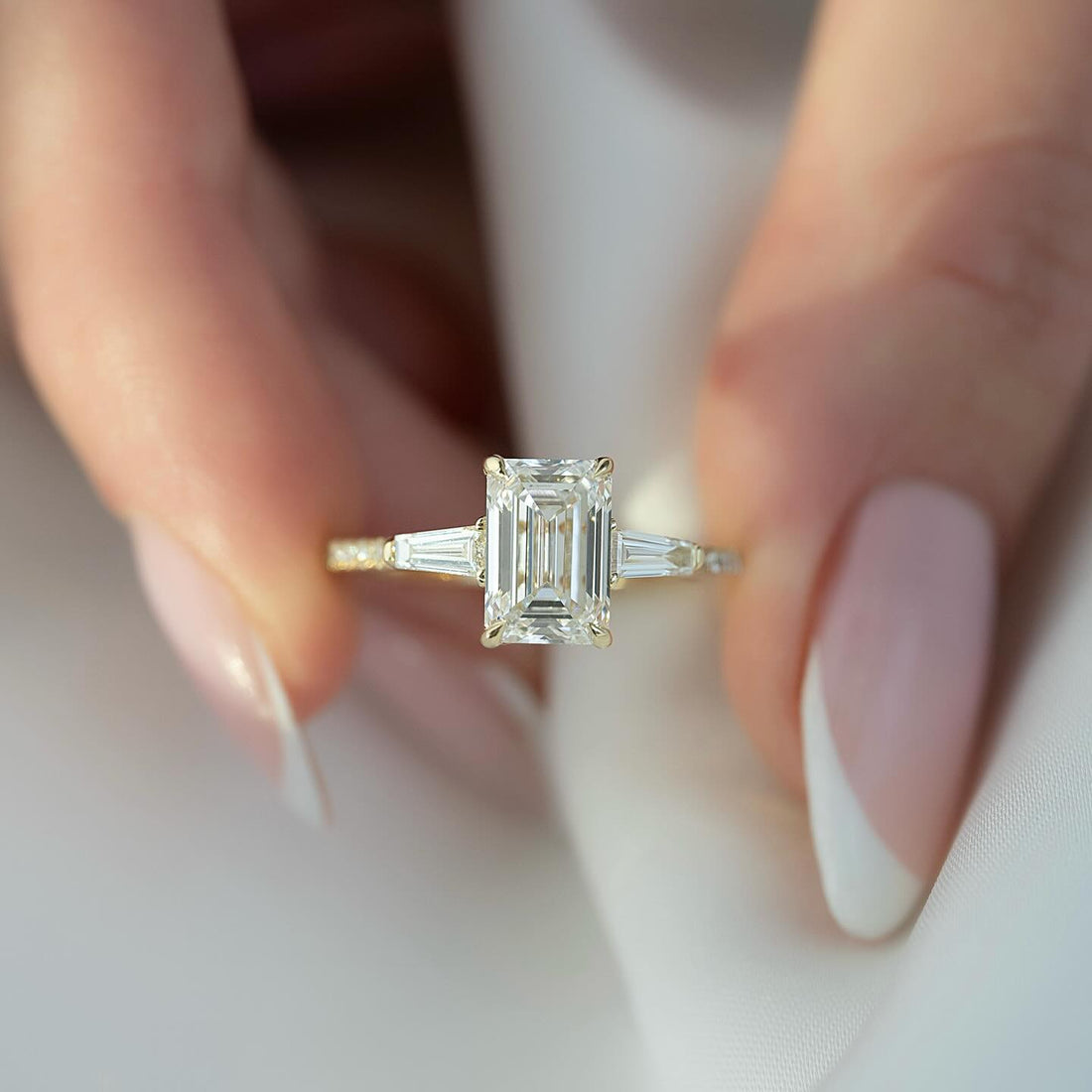 Emerald cut lab grown diamond ring in yellow gold with tapered baguette side stones and a pave band