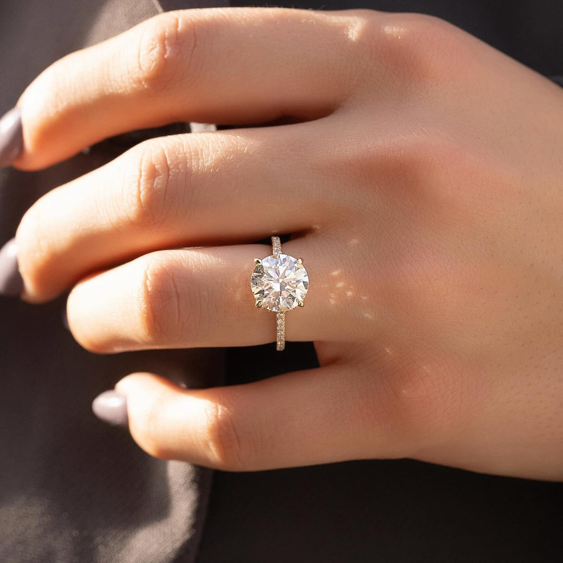 Round lab grown diamond ring with full eternity pave shank in yellow gold worn on hand