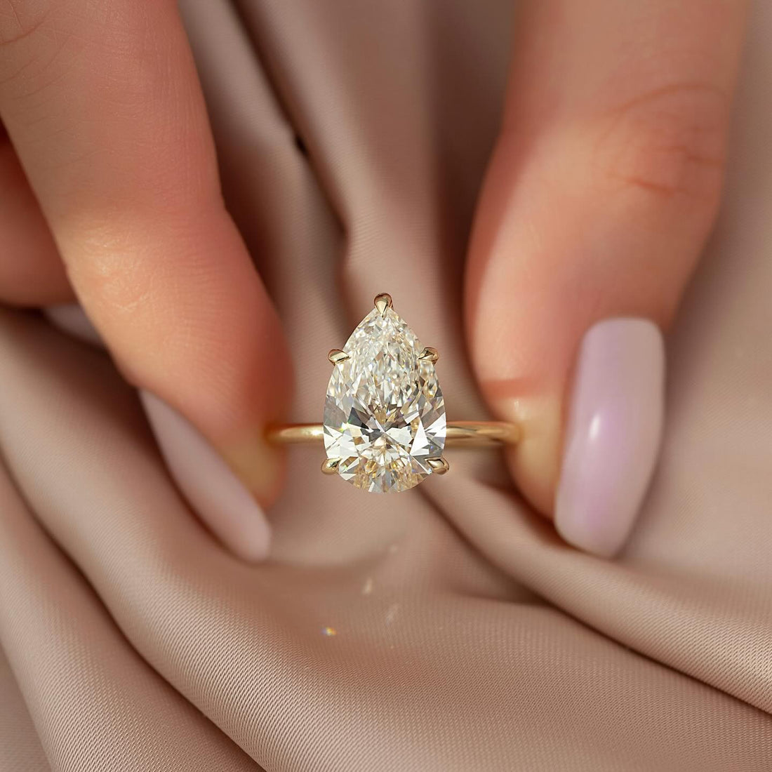 Pear shape lab grown diamond ring with five tapered claw prongs in yellow gold