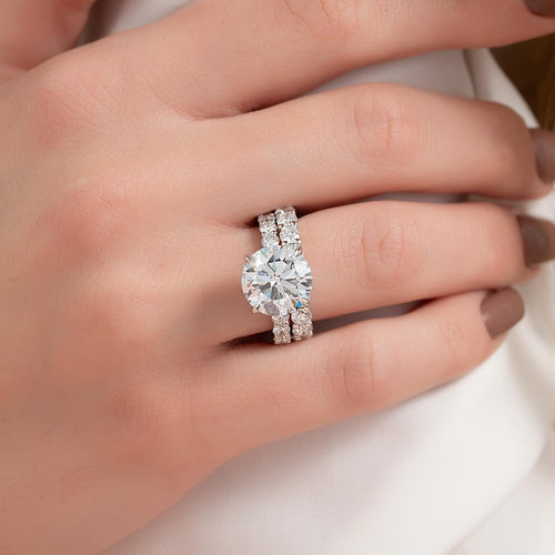 Round cut lab grown diamond bridal ring set with eternity band shank worn on the hand