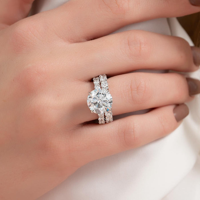 Round cut lab grown diamond bridal ring set with eternity band shank worn on the hand