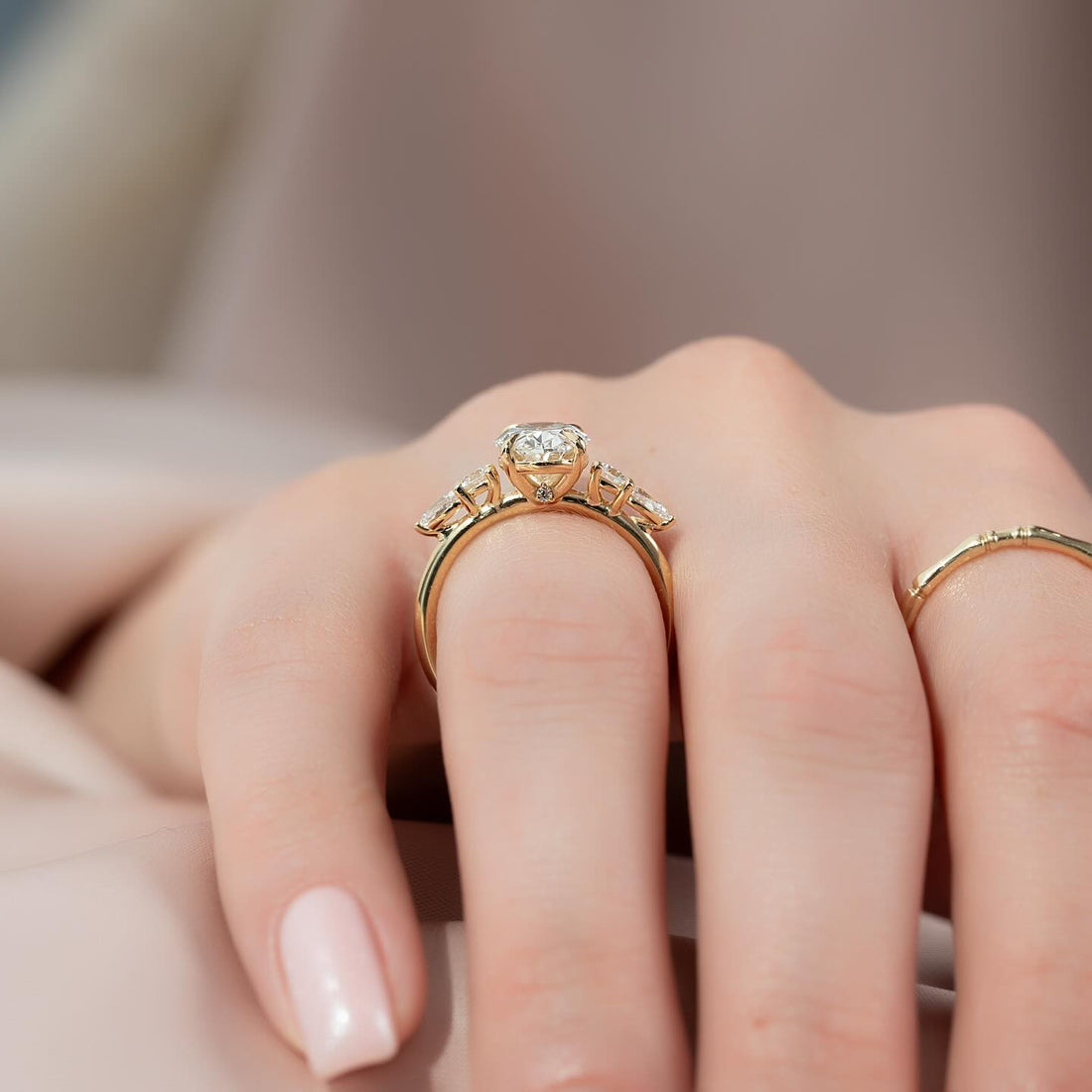 Round brilliant lab grown diamond three stone ring with angled marquise side stones in yellow gold