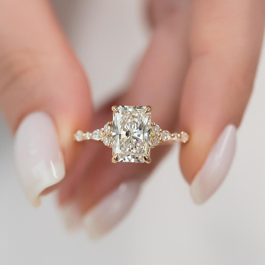 Radiant cut lab grown diamond ring with trefoil cluster shoulders and marquise stations
