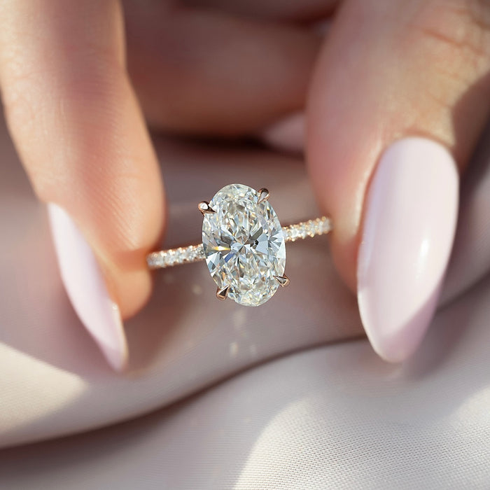 Oval cut lab grown diamond ring on a fine pave rose gold band