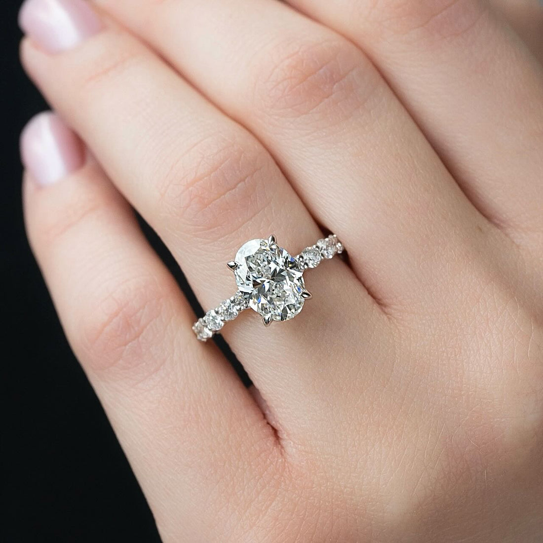 Oval lab grown diamond ring with graduated shared prong diamond band in white gold