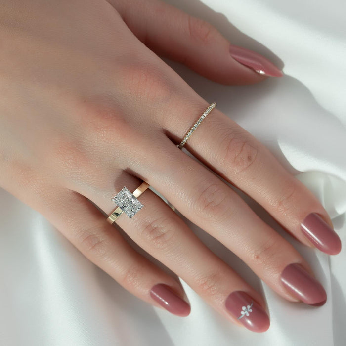 Radiant cut lab grown diamond ring with white metal head on a yellow gold flat edge band