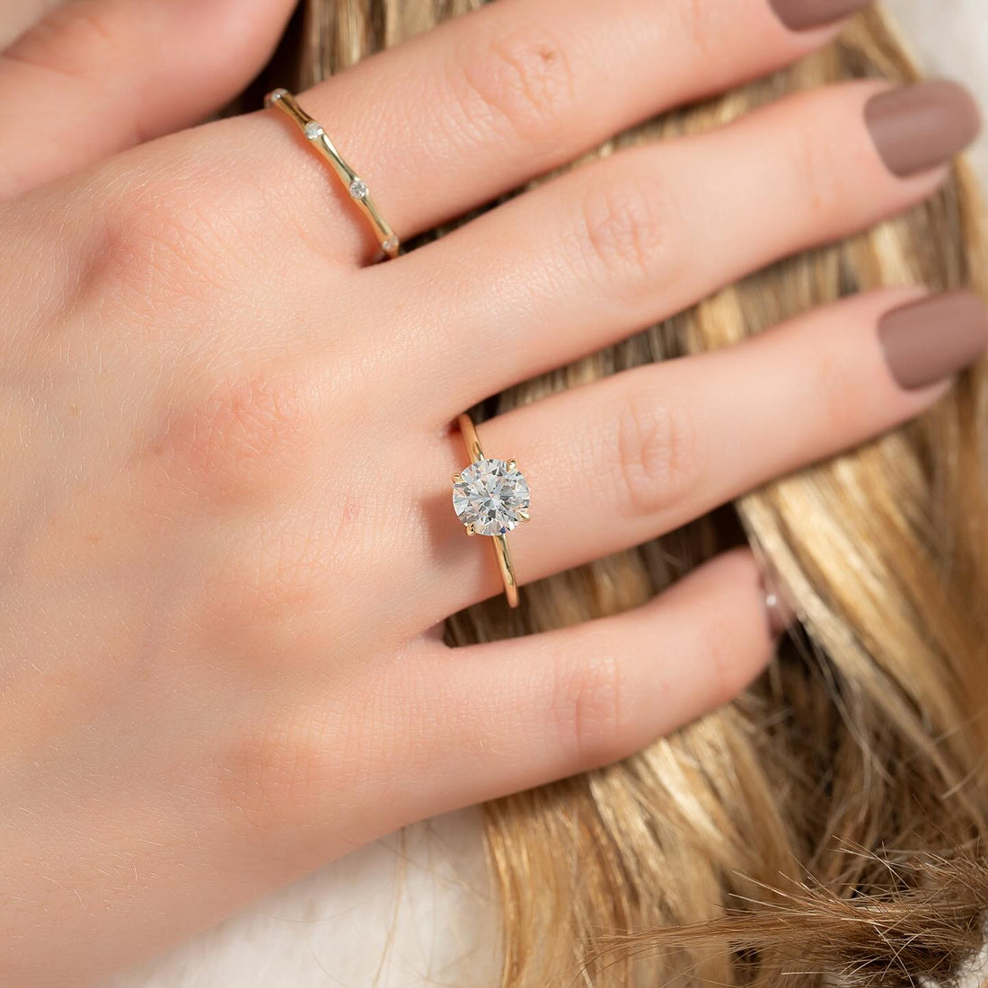 Round cut lab grown diamond solitaire with six claw setting in yellow gold worn on the hand