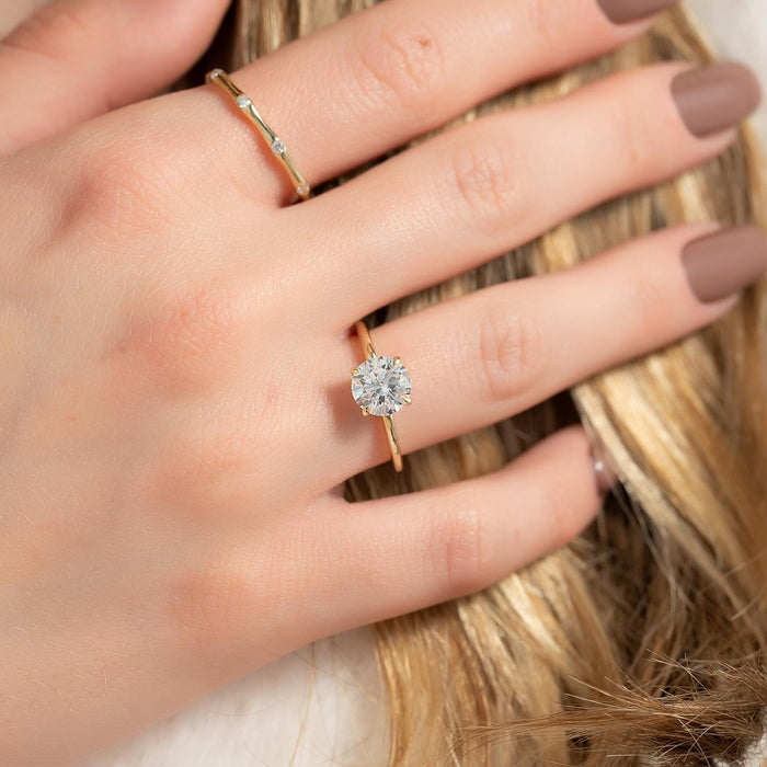 Round cut lab grown diamond solitaire with six claw setting in yellow gold worn on the hand