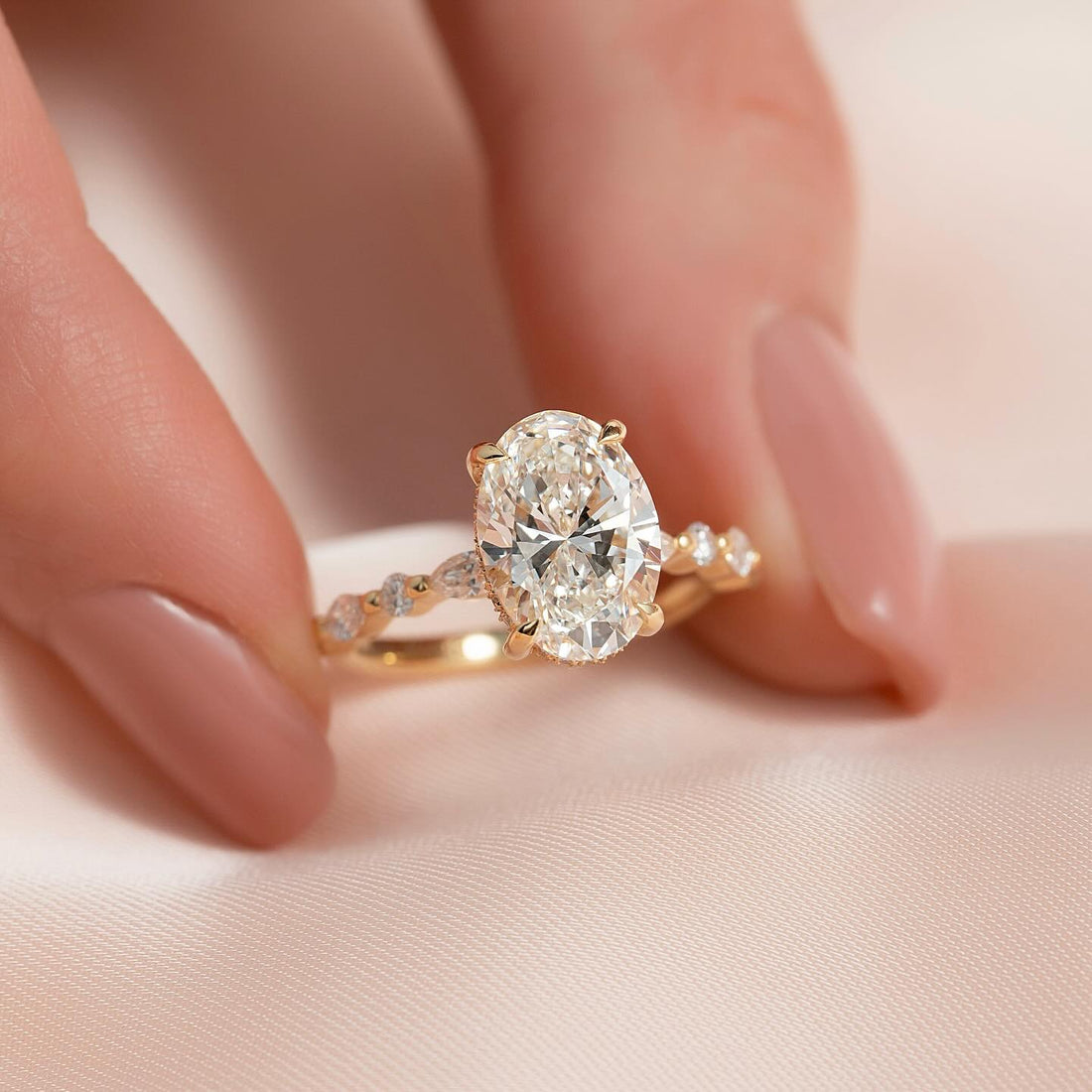 Oval cut lab grown diamond ring with hidden halo and marquise station band in yellow gold