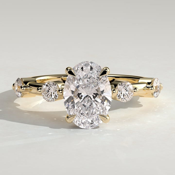 Oval cut lab grown diamond hidden halo ring with spaced round accents in yellow gold