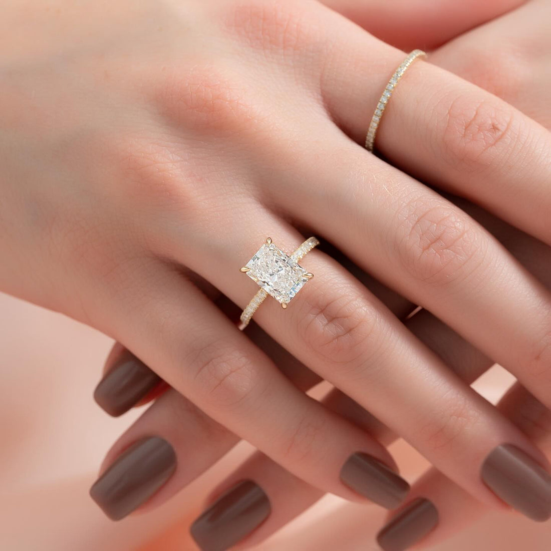 Radiant cut lab grown diamond ring with micro pave shank in yellow gold worn on the hand