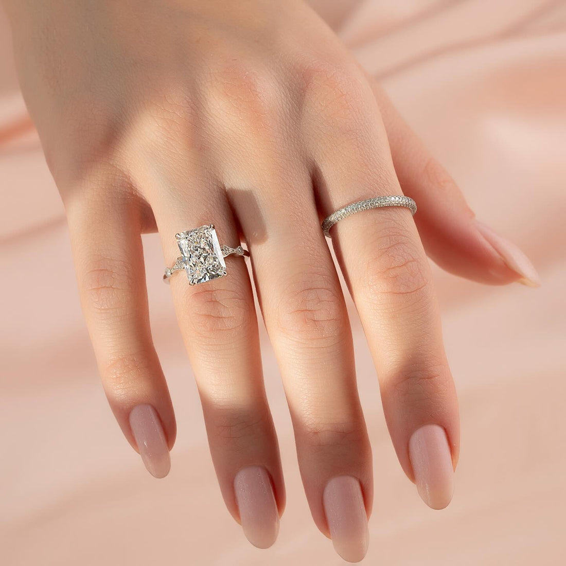Elongated radiant lab grown diamond ring with slender pave shank in white gold worn on the hand