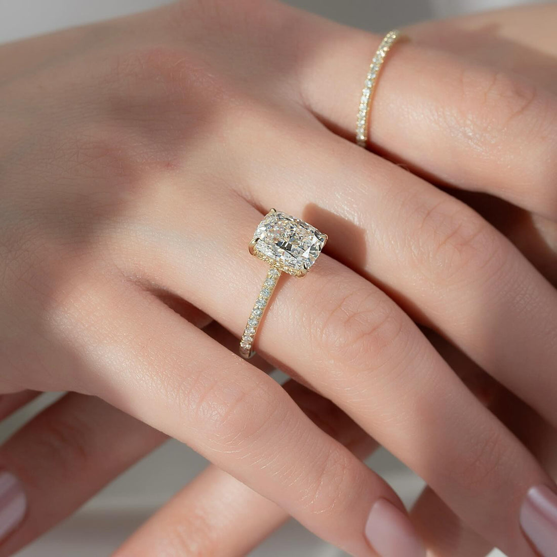 Elongated cushion lab grown diamond ring with hidden halo and three quarter pave band in yellow gold