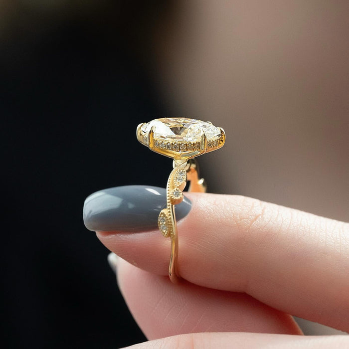 Profile of the marquise ring showing the hidden halo and the milgrain edged leaf plates on the shank