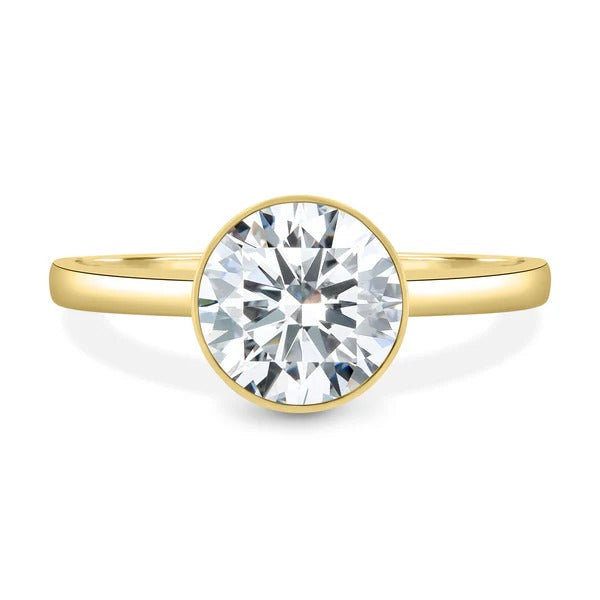 Round cut lab grown diamond bezel set ring with twisted cathedral shoulders