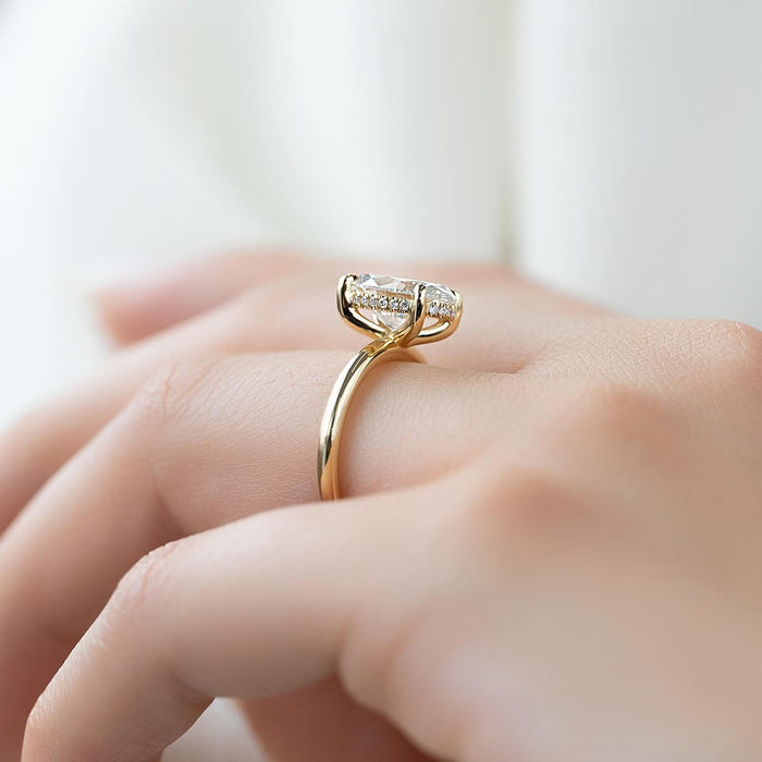 Oval cut lab grown diamond ring in yellow gold with split claws and a concealed halo