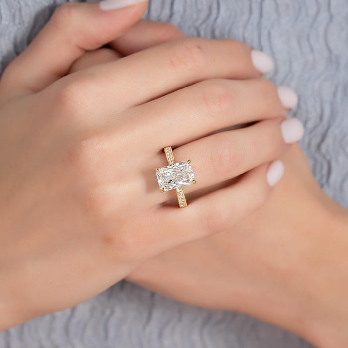Radiant cut diamond ring with pave shoulders worn on the hand