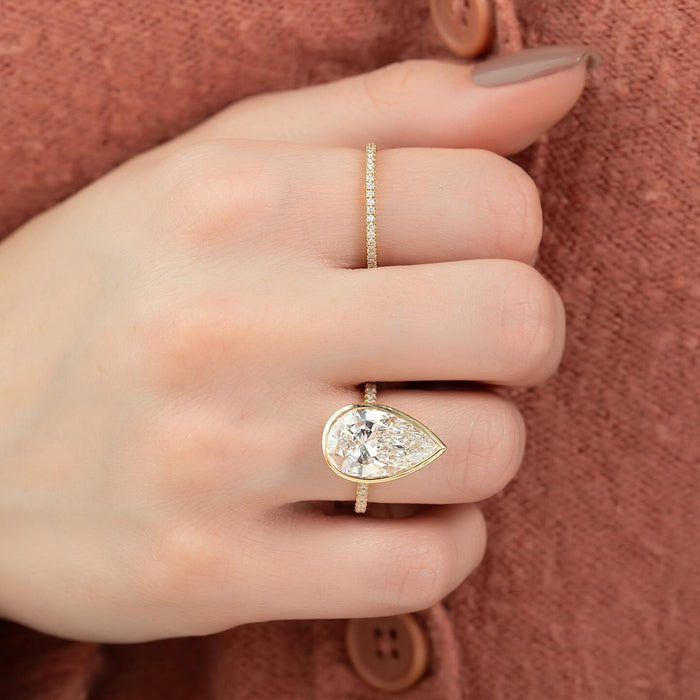 Full bezel rim following the teardrop outline of the pear diamond