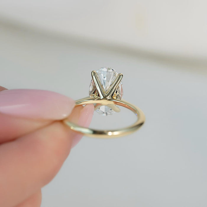 Oval diamond set low across the finger in four claws
