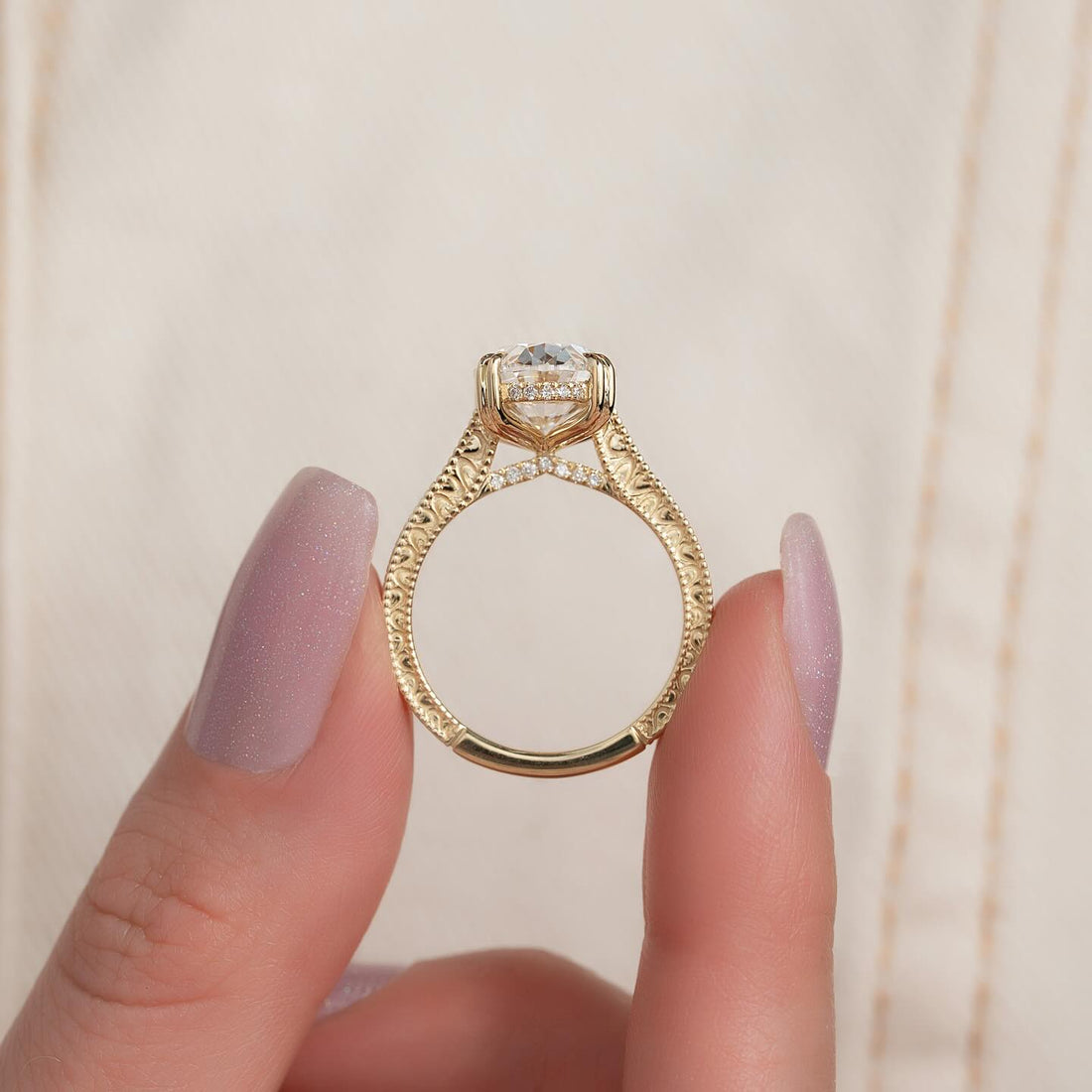 Oval cut lab grown diamond ring with scroll filigree shank and hidden halo in yellow gold