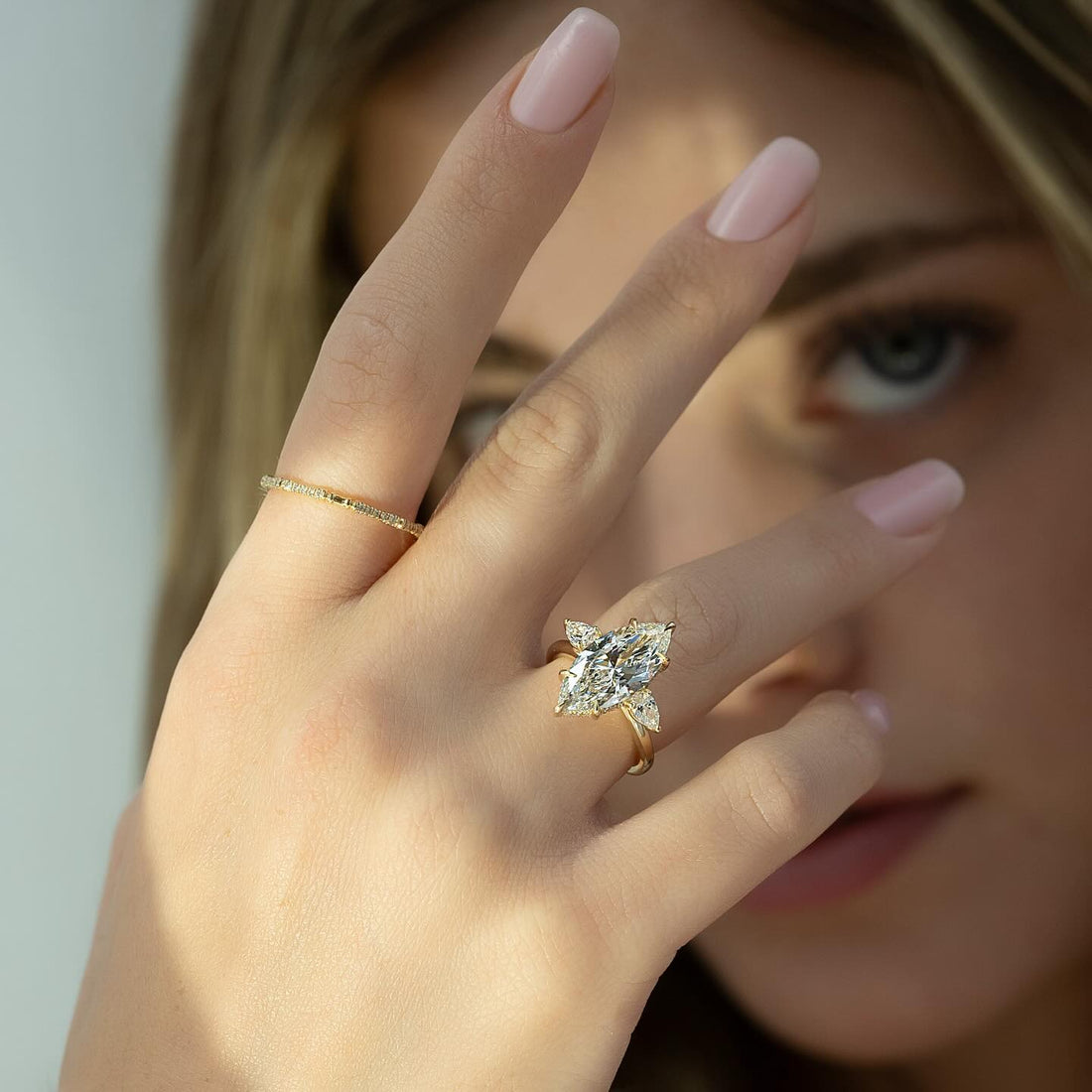 Marquise cut lab grown diamond three stone ring with pear sides on a plain yellow gold band