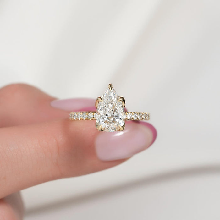 Pear cut lab grown diamond five claw ring on a pave band in yellow gold, front view