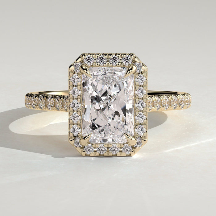 Radiant cut lab grown diamond halo ring on a pave band in yellow gold