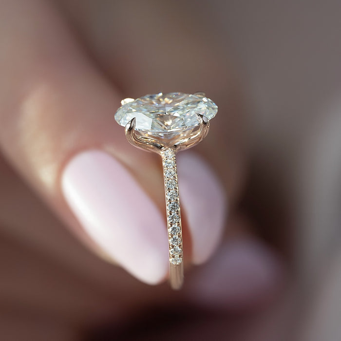 Slim claws and pave shank of the oval rose gold engagement ring