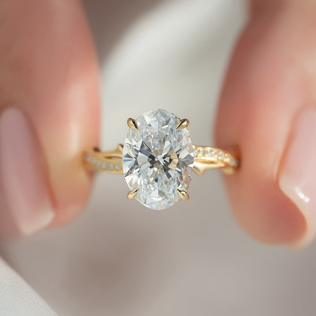 Oval cut lab grown diamond ring in yellow gold on a crossover twist shank with pave
