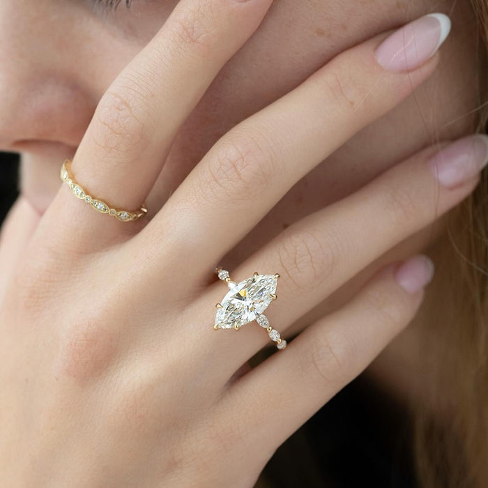 Marquise and round accent stations spaced along the shoulders