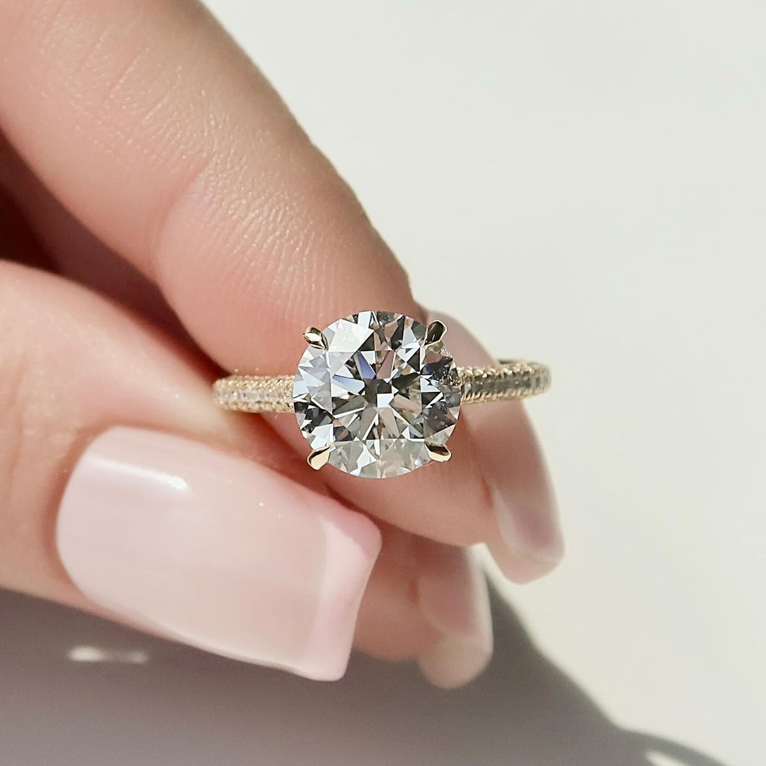 Round brilliant lab grown diamond ring in yellow gold with diagonal claws and wrapped pave shank