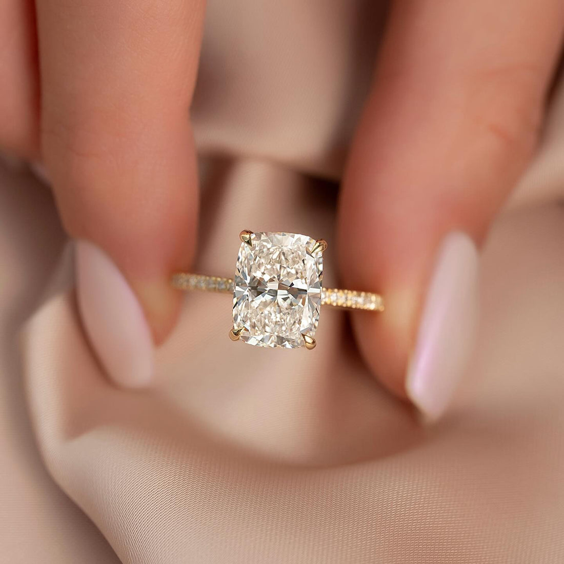 Elongated cushion cut lab grown diamond ring with pave shank in yellow gold