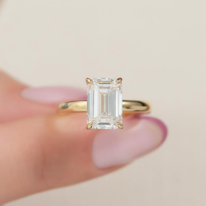 Emerald cut lab grown diamond four claw solitaire ring in yellow gold, front view