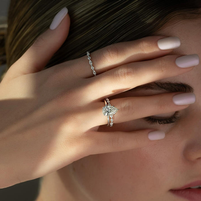 Evenly spaced round accents along the shoulders of the pear ring