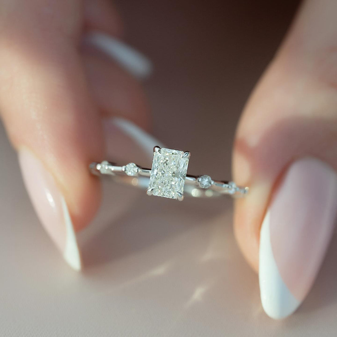 Radiant cut lab grown diamond ring in white gold on a fine band with bead set accents