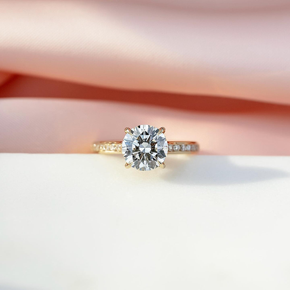 Round brilliant cut lab grown diamond ring on a bright cut pave yellow gold band