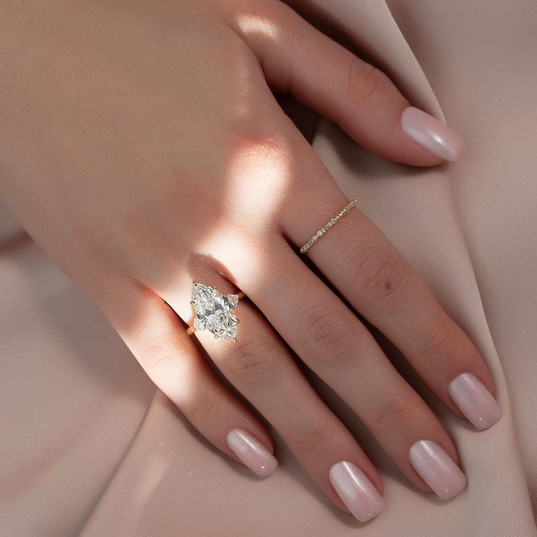 Marquise cut lab grown diamond three stone ring with half moon sides in yellow gold worn on the hand